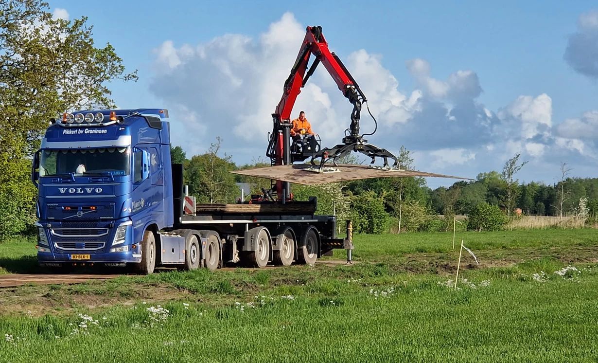 Vrachtwagen met kraan met stempelplaten voor een stabiele werkvloer